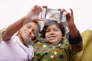 Phone screen, selfie and kid siblings on a floor for fun, vacation or memory at home from above. Smartphone, photography