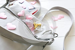 Phone, stylish bag and perfumes on white background. Beautiful flat lay with hearts. The best present for the girl. Woman`s or