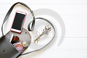 Phone, stylish bag and perfumes on white background. Beautiful flat lay. Things for business woman. Note book schedule. Makeup kit