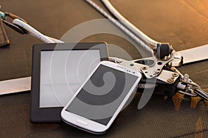 Phone and tablet on a boat at sunset