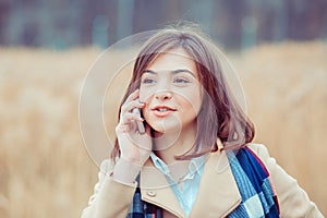 Phone talk. Closeup portrait. Happy woman talking on mobile phone outside outdoors on autumn park background, professional