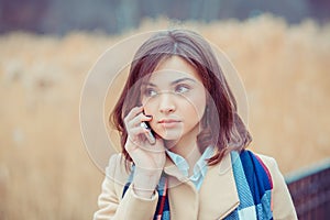 Phone talk. Closeup portrait. Serious woman talking on mobile phone outside outdoors on autumn park background, professional