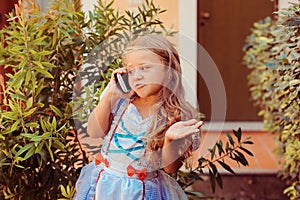 Phone talk I don`t know. Girl child gives explanations on the phone shows dissatisfaction or does not know what he is asking