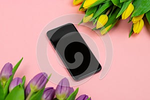 Phone and tulips on pink background