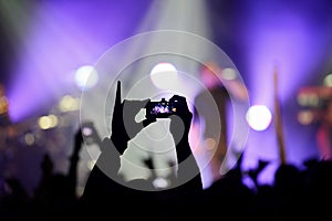 Phone video recording the performance of a rock band in the concert