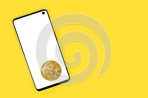 Phone with white mockup and Bitcoin crypto coin with copy space