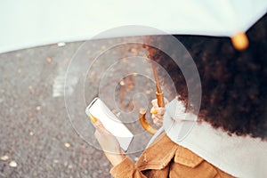 Phone, woman with umbrella and blank screen for marketing, advertising or product placement in city streets. Young black