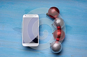 Phone on a wooden table with Christmas toys