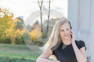 Phoning long haired girl is smiling at the camera