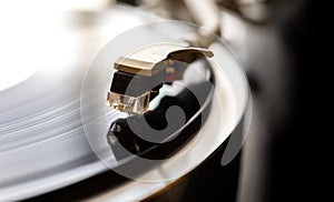 Phono or capsule head of reading LP turntable spinning. Close up of turntable vinyl stylus. Playing record on player photo