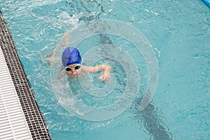 Photo of a 7-year boy playing and swimming in the swimming pool