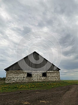 Photo of an abandoned farmhouse. A house in a field. The time before the storm.