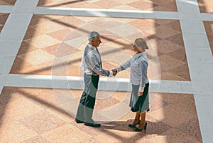 Photo from above of mature man and woman dressed in business suits