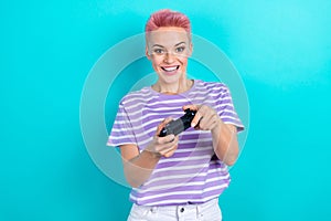 Photo of addicted funny young lady pink dyed short hair hipster playing wireless joystick mortal kombat isolated on cyan