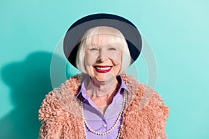 Photo of adorable cute senior lady wear retro jacket headwear smiling isolated teal color background