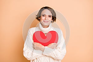 Photo of adorable cute young lady hold embrace big red paper heart love isolated on beige color background