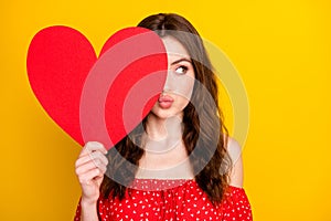 Photo of adorable lady hand hold heart symbol postcard kiss lips look empty space isolated on yellow color background