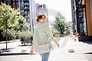 Photo of adorable optimistic girl dressed in sstylish clothes handbag going store mall nice weekend pastime alone