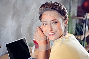 Photo of adorable peaceful lady sit desktop white beaming smile wear yellow t-shirt in modern house indoors