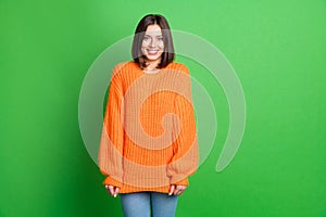 Photo of adorable positive shy girl toothy smile knitwear empty space ad isolated on green color background