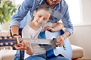 Photo of adorable pretty girl and man hold guitar teaching new chord at home