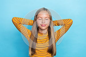 Photo of adorable sweet girl closed eyes arms behind head take nap  on blue color background