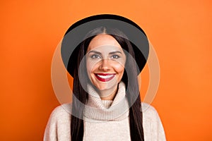 Photo of adorable sweet young lady dressed beige pullover cap smiling isolated orange color background