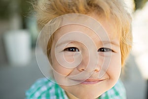 Photo of adorable young happy boy looking at camera. Happy funny child face close up. Super smile from kid. Happiness.