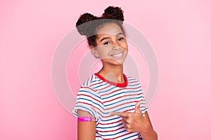 Photo of african american brunette small childhood stylish girl wear t-shirt model point vaccine isolated on pink color