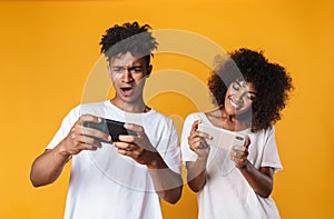 Photo of african american people playing online game on cellphone