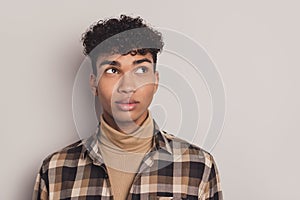 Photo of african guy curious look empty space think wear checkered shirt rollneck isolated grey color background