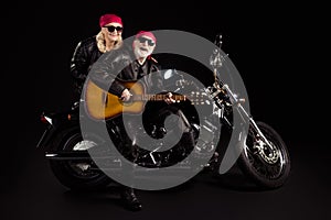 Photo of aged bikers man lady couple sit chopper moto feel young rock bike festival meeting play sing guitar band wear