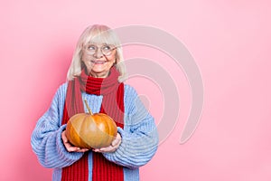Photo of aged lady hold eco vegetables look empty space curious think isolated over pink color background