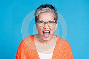 Photo of aged lady yell loud wear orange cardigan isolated on blue color background