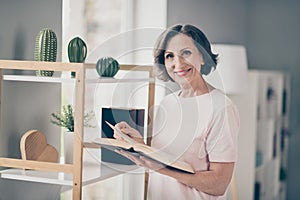 Photo of aged nice brunette lady read book wear pink t-shirt at home alone