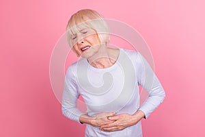 Photo of aged woman hands on stomach eat spoiled food infection spasm isolated over pink color background