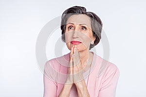 Photo of aged woman hands together beg pray wish look empty space isolated over grey color background