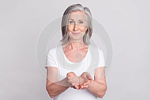 Photo of aged woman happy positive smile hold hands advert product give take isolated over grey color background