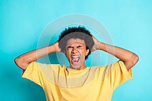 Photo of aggressive furious guy with afro hairdo dressed yellow t-shirt holding hands on head shout isolated on