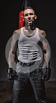 Photo of aggressive man and red boxing bag