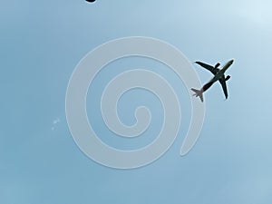 photo of an airplane flying over the sky with sunny and hot weather