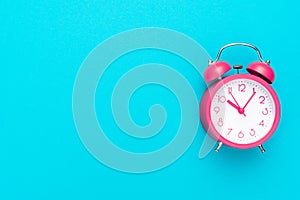 Photo of alarm clock over turquoise blue background with copy space