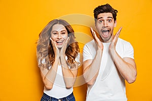 Photo of amazed couple man and woman in basic clothing screaming