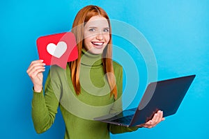 Photo of amazed happy pretty young woman hold hands laptop like icon blogger isolated on blue color background