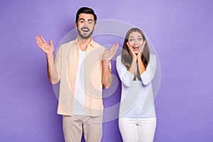 Photo of amazed man and woman couple raise hands hold cheekbones lucky discount isolated on violet color background