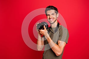 Photo of amazing guy with photo digicam making creative shots wear casual grey t-shirt isolated on red background