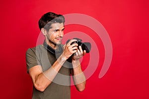 Photo of amazing guy with photo digicam making pictures wear casual grey t-shirt isolated on red background