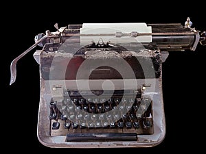 Photo of an ancient, worn-out typewriter on the black background