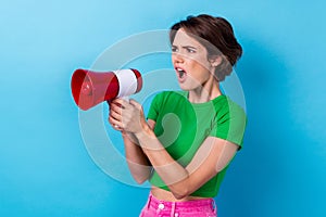 Photo of angry serious lady dressed green top shouting loudspeaker empty space isolated blue color background