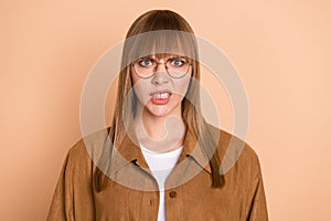 Photo of angry unhappy upset young woman irritated bad mood wear glasses isolated on pastel beige color background